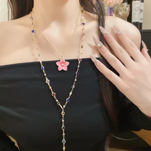 Close-up of layered beaded necklace with pink enamel flower pendant in vintage style