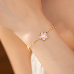 Detailansicht eines eleganten rosa Blumenarmbands mit Vergoldung und Zirkonstein am Handgelenk