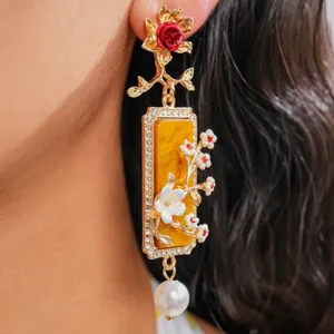 Détail rapproché d'une élégante boucle d'oreille florale en résine avec cristaux et perle