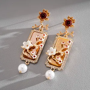 Détail de boucles d'oreilles fleuries de style palais vintage avec perles et cristaux