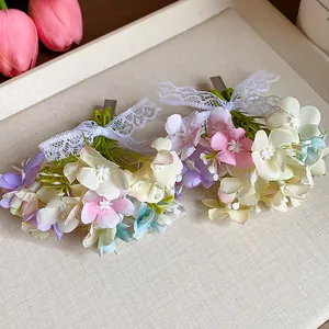 Elegant floral hair clips with lace bows and pastel fabric petals in close-up detail.