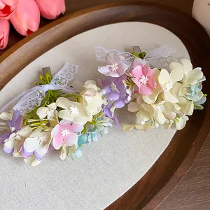 Close-up detail of delicate fabric flower and lace bow hair clips in a wooden tray
