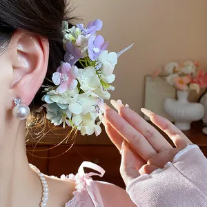Close-up of elegant fabric floral hair clip and pearl earrings for women