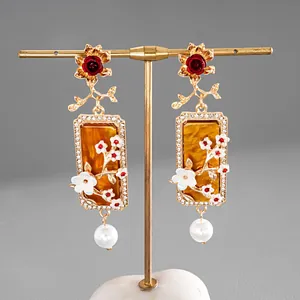 Boucles d'oreilles vintage élégantes en résine avec fleurs et perles blanches fines.