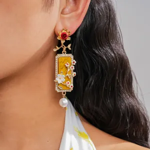 Détail en gros plan d'une boucle d'oreille florale vintage avec résine et perle sur modèle