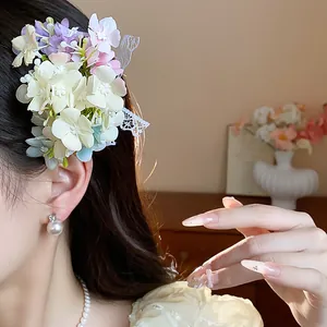 Detailed view of an elegant floral hair clip with white lace accents worn by a model