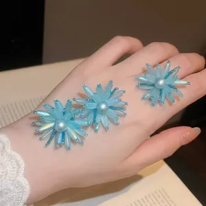 Süßes blaues Acryl-Blumenschmuck-Set für den Sommer mit eleganten Perlenakzenten auf der Hand