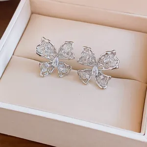 Dettaglio di orecchini a lobo a farfalla traforati argento con zirconi brillanti