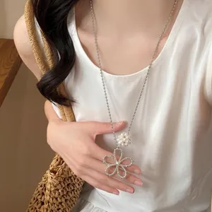 Close-up detail of a French style hollow flower necklace with pearl bead cluster