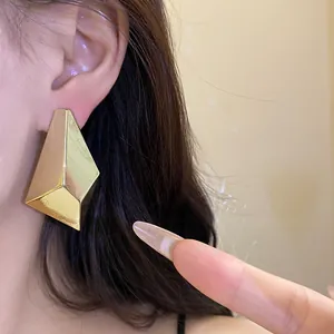 Macro detail of elegant gold geometric faceted stud earrings for daily wear style