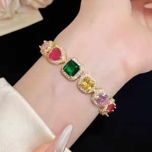 Detailed view of a multi-color gemstone bracelet with gold-plated setting on a wrist