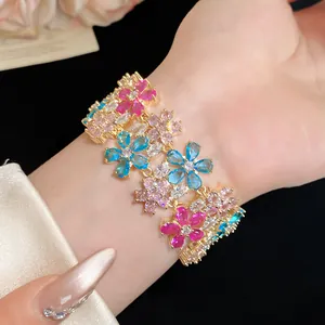Detailed view of 18k gold plated bracelet with colorful zircon flower motifs on wrist.