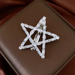 Close-up of a vintage star hair clip featuring sparkling clear zircons on a brown display.
