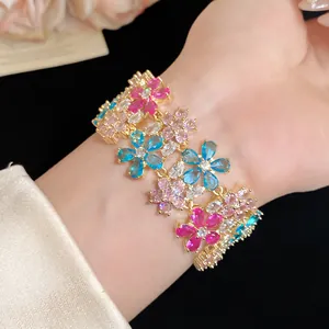 Detailed macro view of an 18k gold plated multi-colored zircon flower bracelet on a wrist