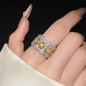 Close-up of a vintage-style flower ring with white zircons and yellow blossoms.