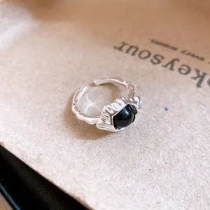 Close-up detail of the vintage silver open ring featuring a polished oval black stone