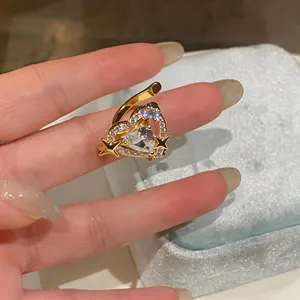 Dettaglio dell'ear cuff a forma di cuore dorato con zirconi brillanti e stelle