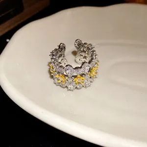Detailed macro view of an elegant zircon flower open ring with gold-tone accents