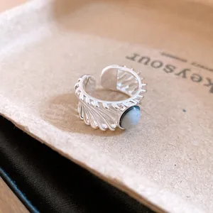 Detailed close-up of a vintage hollowed silver open ring with unique oval stone inlay