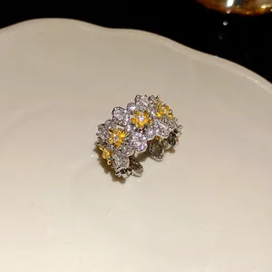 Close-up of an exquisite floral open ring featuring sparkling white and yellow zircon stones.