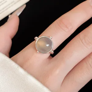 Detailed view of a minimalist silver open ring with a round translucent stone