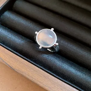 Close-up of minimalist silver ring featuring a round translucent moonstone