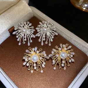 Fireworks-inspired stud earrings with pearls and zircons in gold and silver finish.