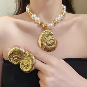 Vista detallada de un collar de perlas retro con un gran colgante de caracola dorada