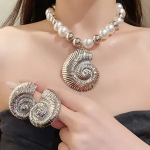 Vista detallada del conjunto de collar de perlas y pendientes de caracola en modelo