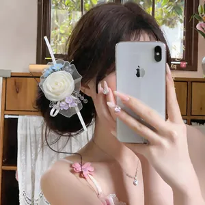 Elegant forest style chiffon rose hair clip with pearl details worn by a model in mirror selfie