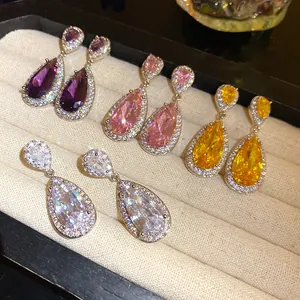 Dettaglio di orecchini pendenti in zircone colorato a forma di pera in un vassoio portagioie