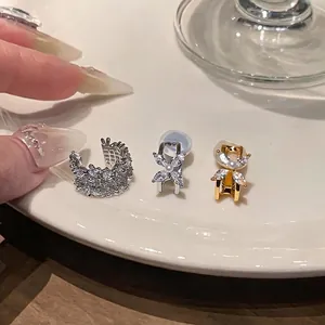 Elegant flower ear clips with sparkling zircons and pearls on white ceramic plate