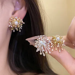 Close-up of elegant fireworks-inspired earrings with pearls and stars in gold and silver.