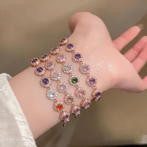 Vista dettagliata di eleganti bracciali in oro rosa con zirconi rotondi colorati sul polso
