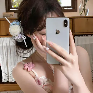 Detailed macro view of an elegant white chiffon flower duckbill clip on dark hair