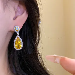 Dettaglio di eleganti orecchini a goccia in zircone giallo con splendidi riflessi