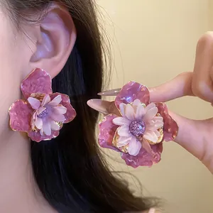Vista detallada de pendientes de flores rosas grandes con pétalos de textura