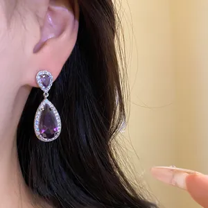 Eleganti orecchini in zircone a goccia viola su modella per un look di gioielleria raffinato
