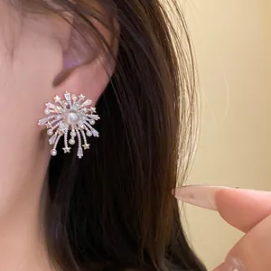 Elegant silver firework stud earrings featuring zircon and pearl accents on a model's ear