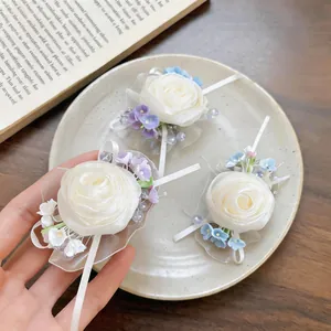 Close-up detail shot of elegant white chiffon rose hair clips with delicate ribbon accents.