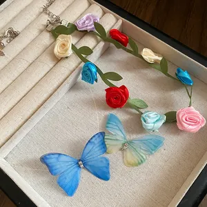 Close-up of colorful fabric rose choker and mesh butterfly pendant in a jewelry box