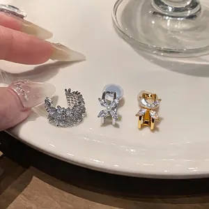 Close-up of elegant zircon flower ear clips and a sparkling silver cuff on a plate.