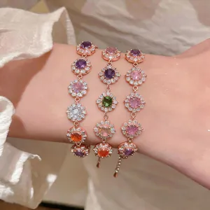 Primo piano di bracciali in zircone oro rosa con pietre preziose a forma di fiore.