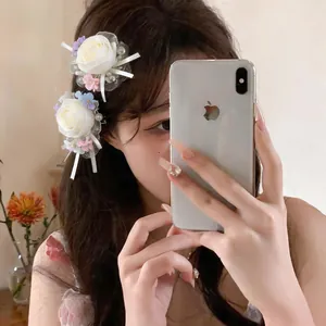 Elegant white chiffon rose hair clips with pearls and silk ribbons on a model