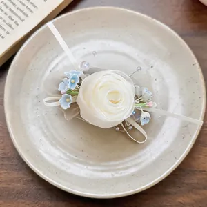 Detailed close-up of an elegant chiffon rose hair clip with blue accents on a ceramic plate