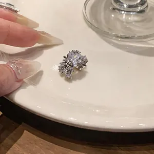Detailed macro view of a luxury zircon floral ear cuff placed on a white porcelain plate.