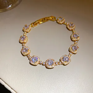 Détail d'un bracelet plaqué or 18 carats avec breloques carrées en zircons étincelants