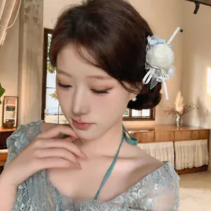Detail view of an elegant Mori-style chiffon flower hair clip on a model's hair