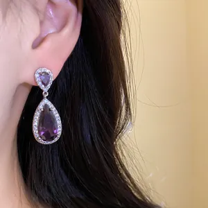 Dettaglio ravvicinato di eleganti orecchini in zircone viola a goccia per un look di lusso