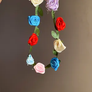 Close-up detail of a handmade colorful ribbon rose choker with green leaf accents